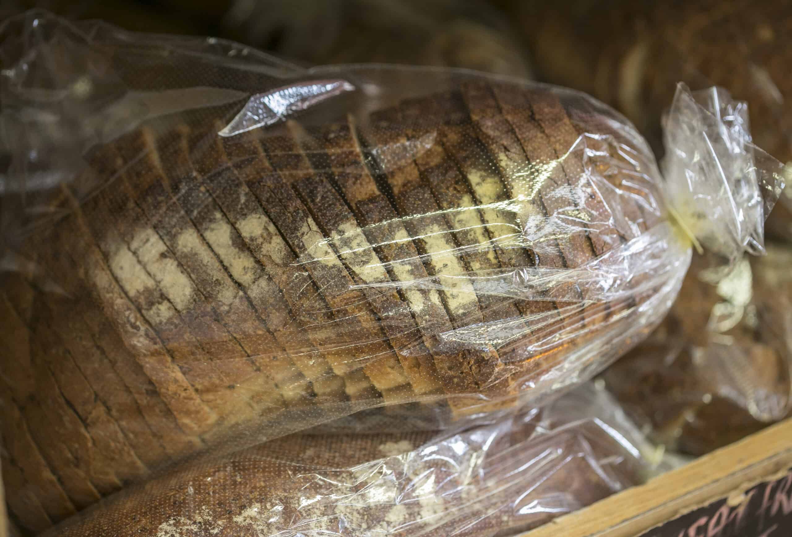 Freshly sliced brown bread in plastic wrap at The Auld Mill Bakery.