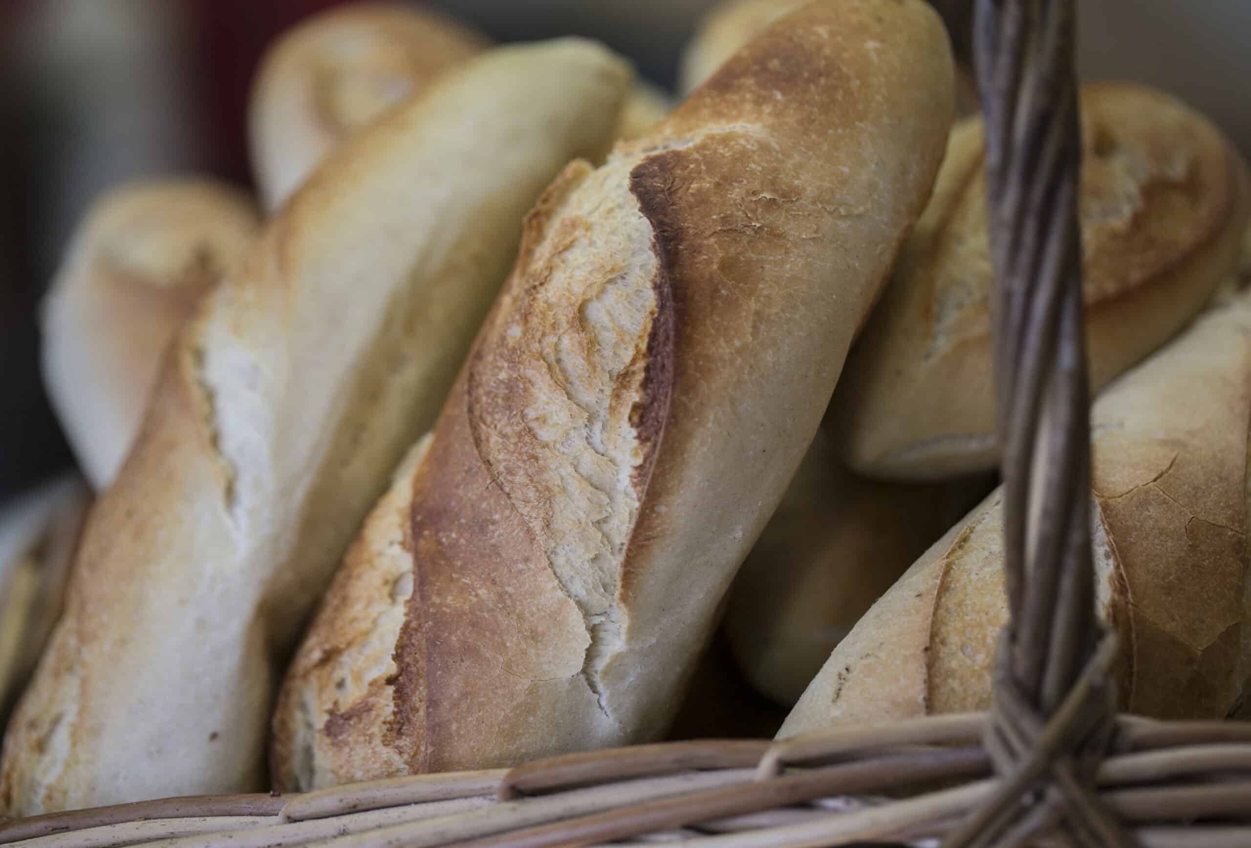 Freshly baked French baguettes in a woven basket at The Auld Mill Bakery. Perfect for breakfast, san.