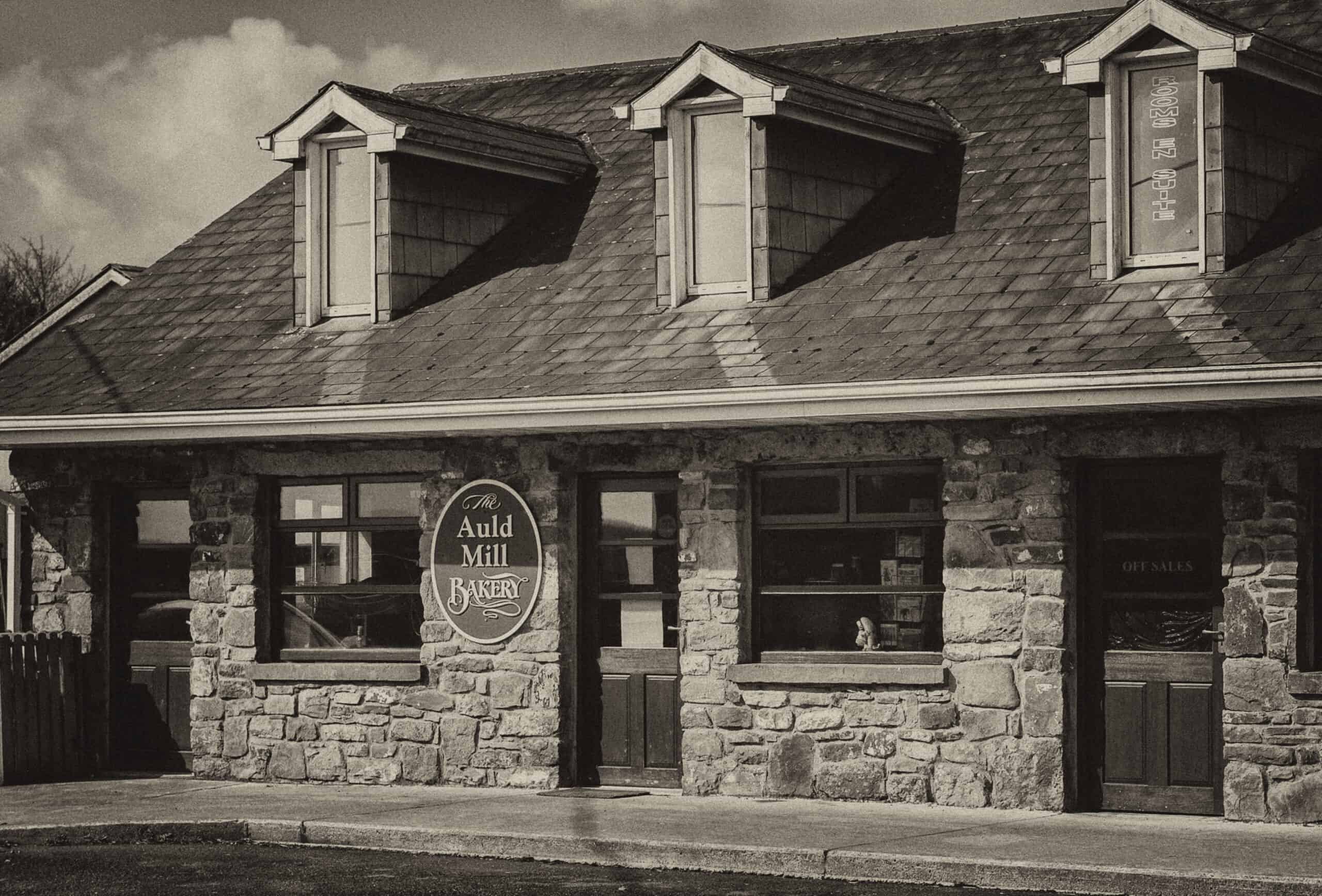 Bakery storefront with stone facade and classic signage, showcasing a cozy, inviting atmosphere for.